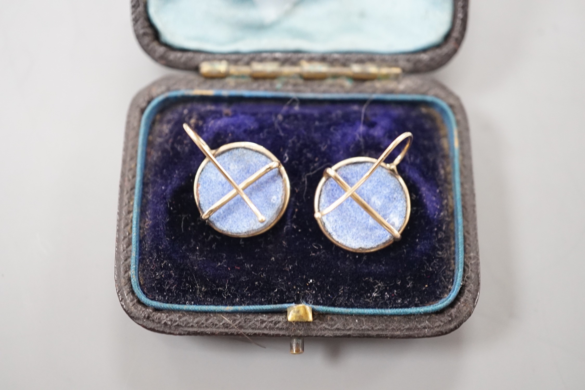 A cased pair of yellow metal and circular enamel earrings, decorated with the heads of a dog, diameter 14mm, gross weight 2.8 grams.